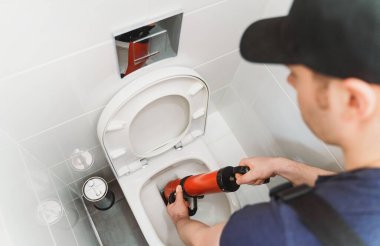Profesyonel güç pompası temizleyicisiyle tıkanan tuvaleti açıyorum..