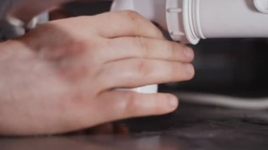 Tesisatçı banyo tuzağı kuruyor. Yakın çekim görünümü.