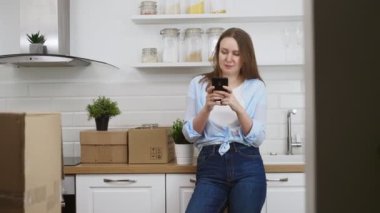 Kadınlar yeni bir daireye taşındıktan sonra akıllı telefonla iletişim kurarlar..