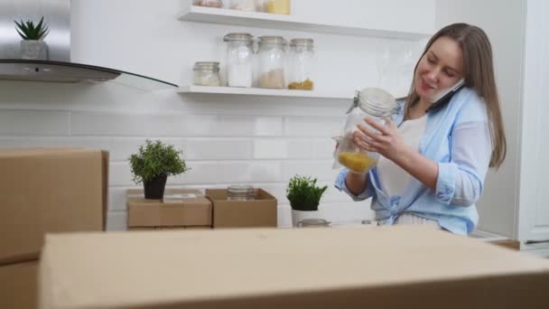 Mulher Falando Pelo Telefone Arranja Utensílios Cozinha — Vídeo de Stock