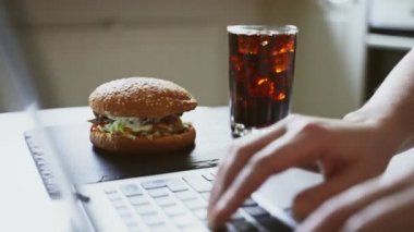 Kadın ve hamburger iş yerinde. Sonsuz acele kavramı.