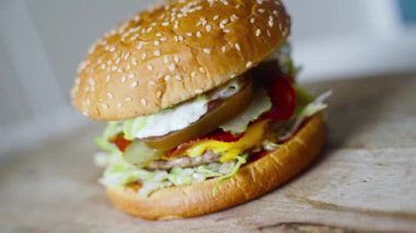 Eldivenli şef bitmiş hamburgeri bastırıyor..