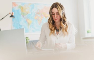 Ofiste belgelerle çalışan bir seyahat acentesi..