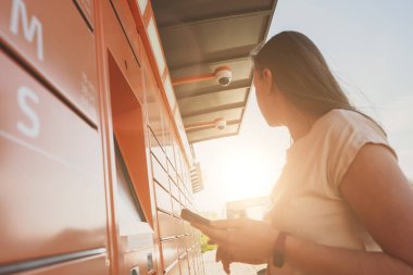 Kadın otomatik otomatik otomatik otomatik servis terminalinden postaları alıyor..