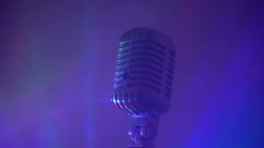 Sahne ışıkları olan klasik mikrofon. Canlı performans veya karaoke konsepti.