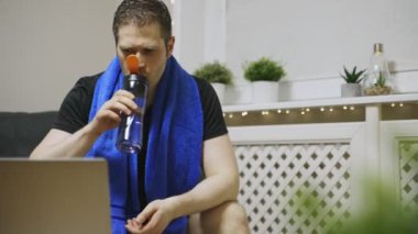 Adam antremandan sonra su içiyor. Evde spor faaliyetleri.