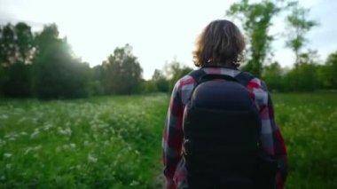 Sırt çantalı bir adam ormanda yürüyor..