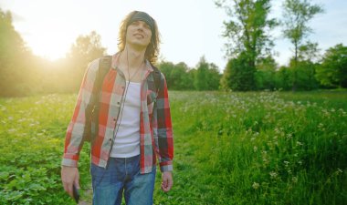 Sırt çantalı kulaklıklı adam yürüyor..