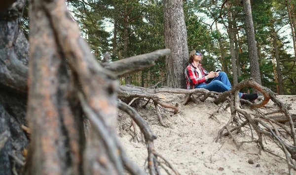 持智能手机的男性游客在森林里休息 — 图库照片