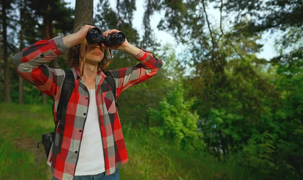 森の中にリュックサックと双眼鏡を持つ男 — ストック写真