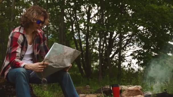 Hombre Con Mapa Sienta Frente Hoguera Bosque — Vídeos de Stock