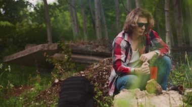 Adam ormanda şenlik ateşinin önünde oturur..