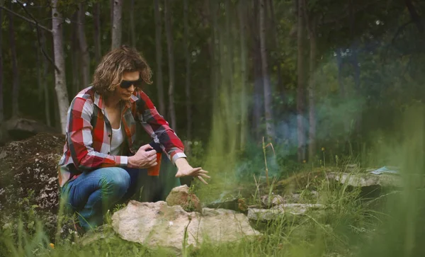 男人坐在森林篝火前 — 图库照片