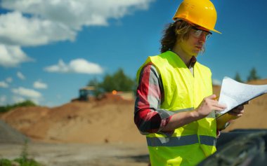 Yol kavşağı inşaat sahasında belgeleri olan inşaat mühendisi..