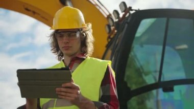 Tablet pc kullanarak sabit kaskta kazıcı operatörü.