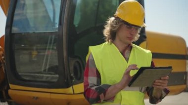 Tablet pc kullanarak sabit kaskta kazıcı operatörü.