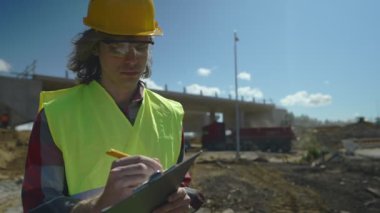 Yol kavşağı inşaat sahasında belgeleri olan inşaat mühendisi..