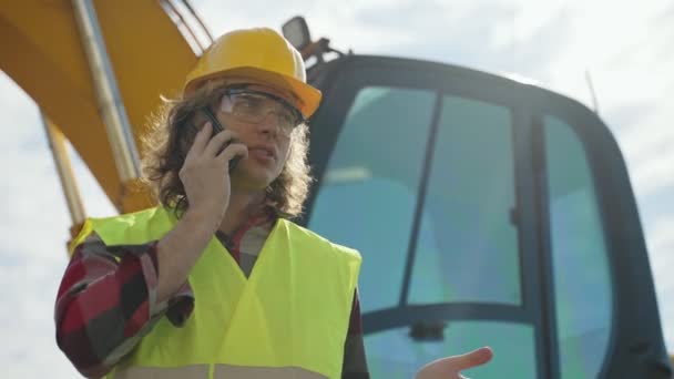 Χειριστής Εκσκαφέα Σκληρό Καπέλο Μιλάει Από Smartphone — Αρχείο Βίντεο