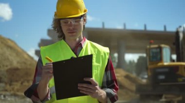 Yol kavşağı inşaat sahasında belgeleri olan inşaat mühendisi..