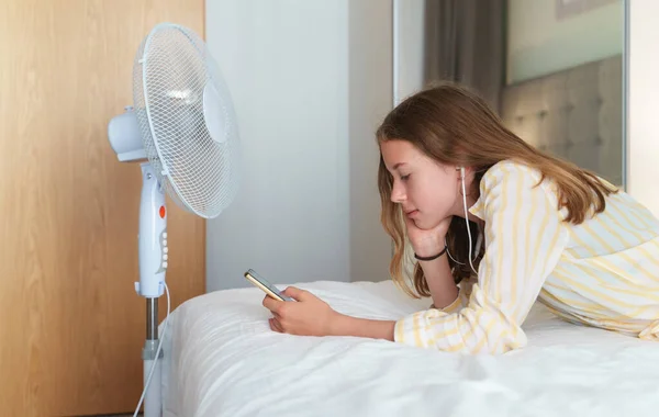 Tiener Ligt Met Telefoon Voor Koelventilator — Stockfoto