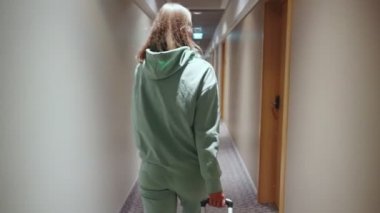 Otele giriş yap. Bavullu kadın otel odasının kapısını açıyor..