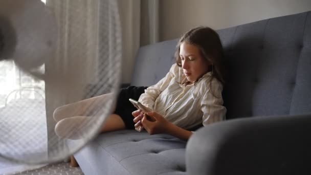 Adolescent Avec Téléphone Devant Ventilateur Refroidissement — Video