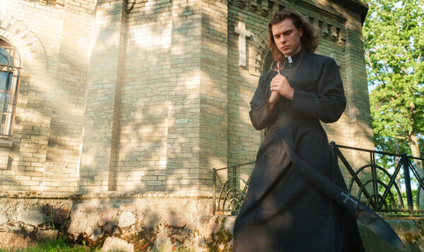 Христианский священник с крестом в руках.