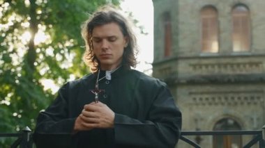 Kilisenin yanında haçlı dua eden Hıristiyan rahip..