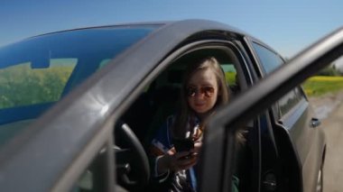 Arabada oturan ve cep telefonu kullanan kadın..