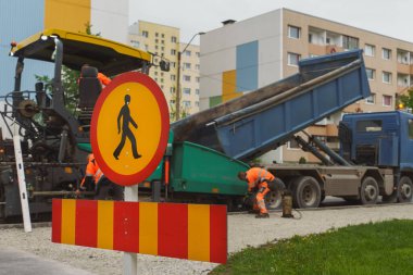 Yolda asfalt istifleme makinesi var..