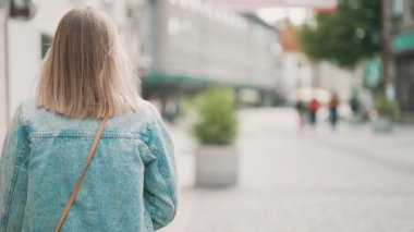 Kot ceketli kadın şehirde yürüyor..