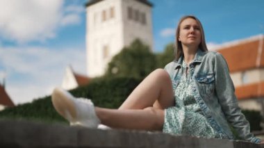 Tallinn 'de kiliseye karşı dinlenen bir kadın..