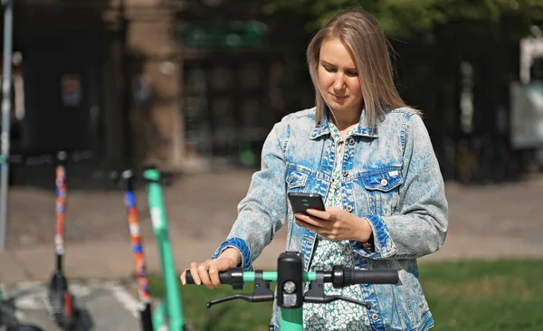 Kobieta Korzystająca Aplikacji Smartfonie Aby Odblokować Skuter Elektryczny Ulicy — Zdjęcie stockowe