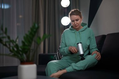 Evde masaj aletli masaj yapan bir kadın..