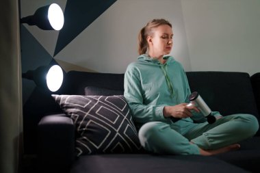 Evde masaj aletli masaj yapan bir kadın..