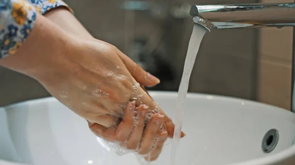 女は流しの中で手を洗う — ストック写真