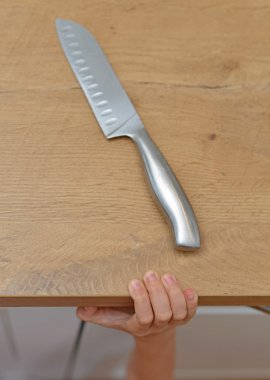 Dangerous situation in the kitchen. Child is trying to get a kitchen knife. clipart