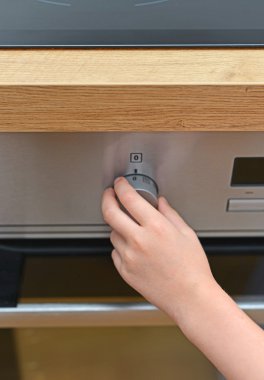 Mutfakta tehlikeli bir durum. Elektrikli fırın ile oynayan çocuk.