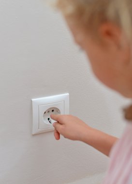 Çocuk parmaklarını yuvaya yapışır. tehlikeli bir durum evde.