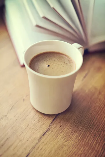 Свежесваренная чашка кофе против книги . — стоковое фото