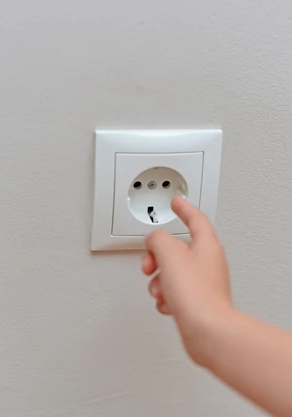 Child sticks his fingers in the socket. Dangerous situation at home. — Stock Photo, Image