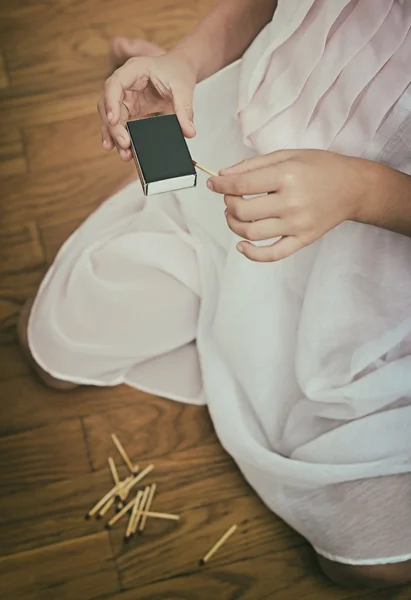 Ragazza che gioca con fiammiferi. Situazione pericolosa a casa . — Foto Stock