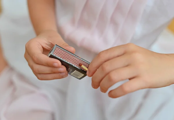 Girl playing with matches. Dangerous situation at home. — Stock Image Girl playing with matches. Dangerous situation at home. Stock Picture