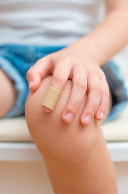 Yapışkan bandajlı çocuk parmağı.