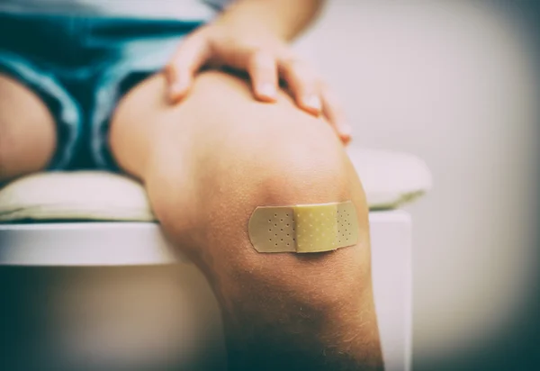 Rodilla infantil con vendaje adhesivo. Efecto vintage . — Foto de Stock