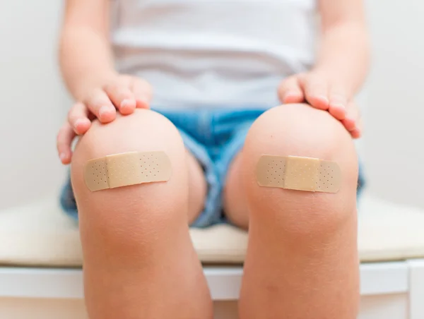 Knie des Kindes mit einem Klebeverband. — Stockfoto