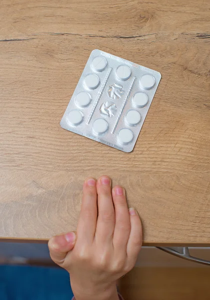 Child takes pack of pills. Dangerous situation. — Stock Photo, Image