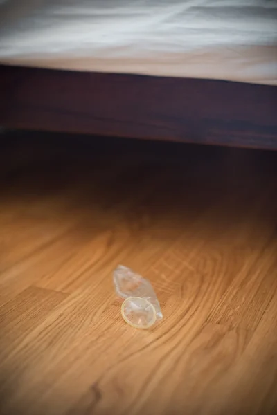 Habitación desordenada en el hotel, condones en el suelo . —  Fotos de Stock