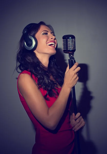 Attractive brunette woman recording a song in music studio. — Stock Photo, Image