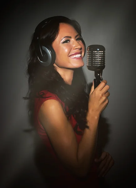 Attraente donna bruna che registra una canzone in studio musicale . — Foto Stock